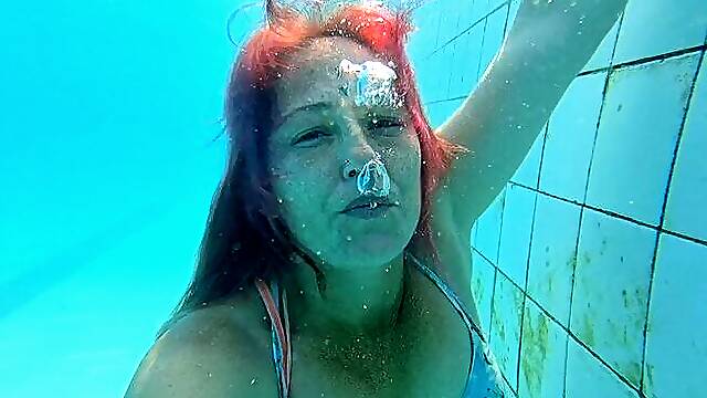 Blowing bubbles underwater in dress